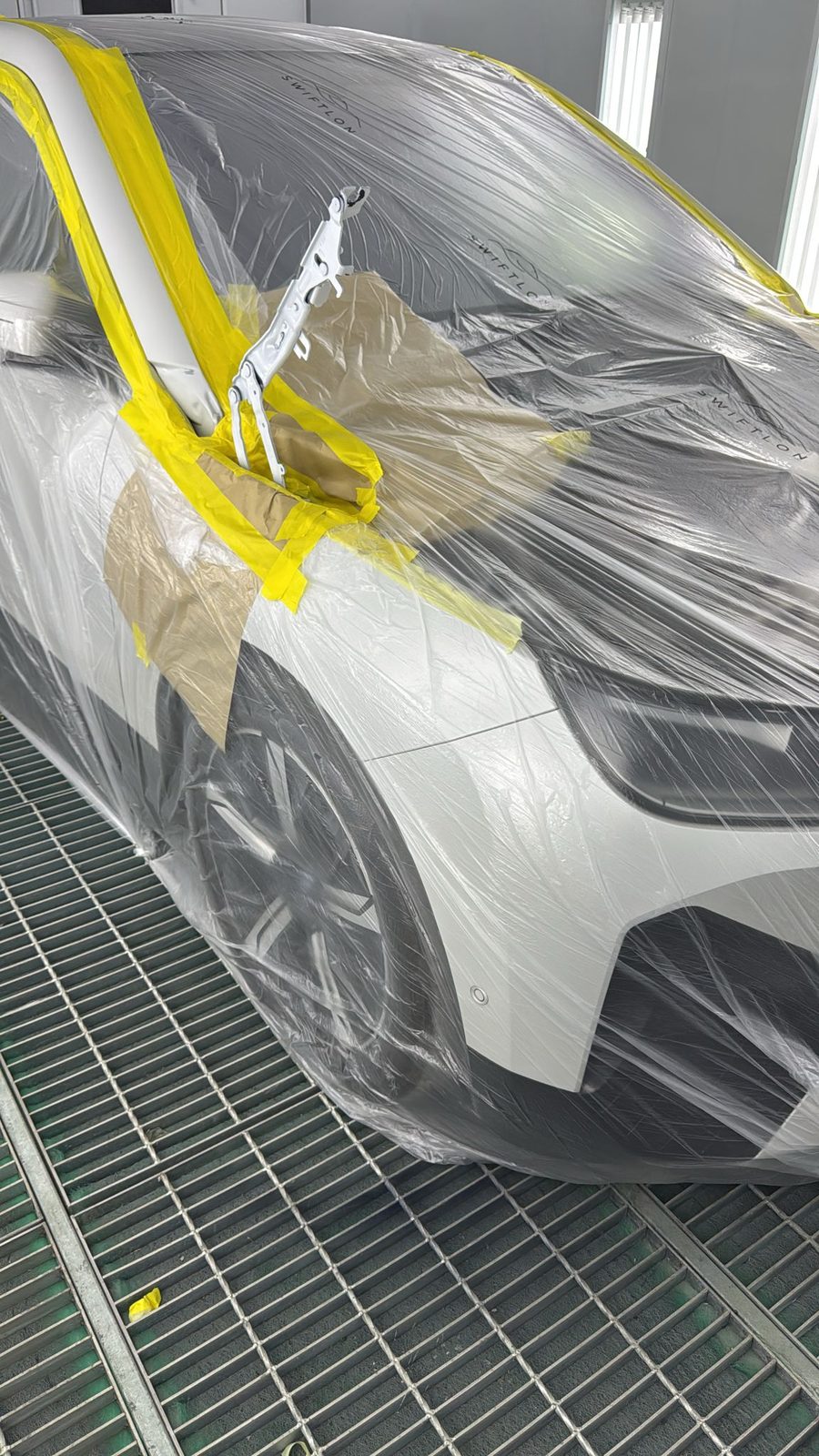 BMW i3 fully masked for paint refinish in the booth